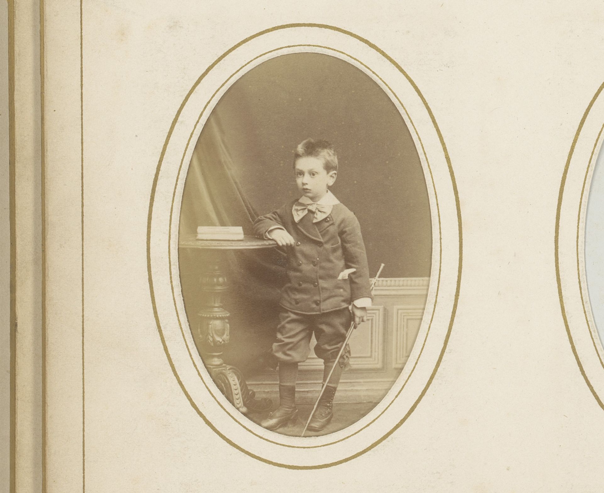 Portret van een jongen met stok in de hand, staand bij een tafel met boek by Albert Delabarre