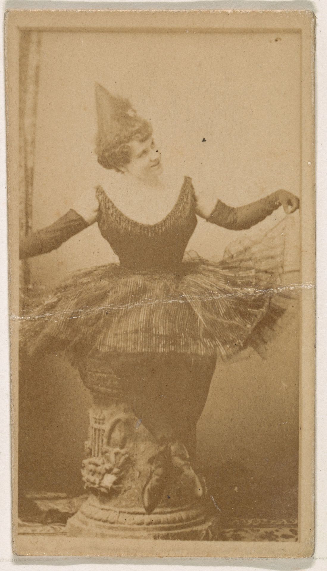 Seated dancer holding skirt, from the Actresses series (N245) issued by Kinney Brothers to promote Sweet Caporal Cigarettes by Kinney Brothers Tobacco Company