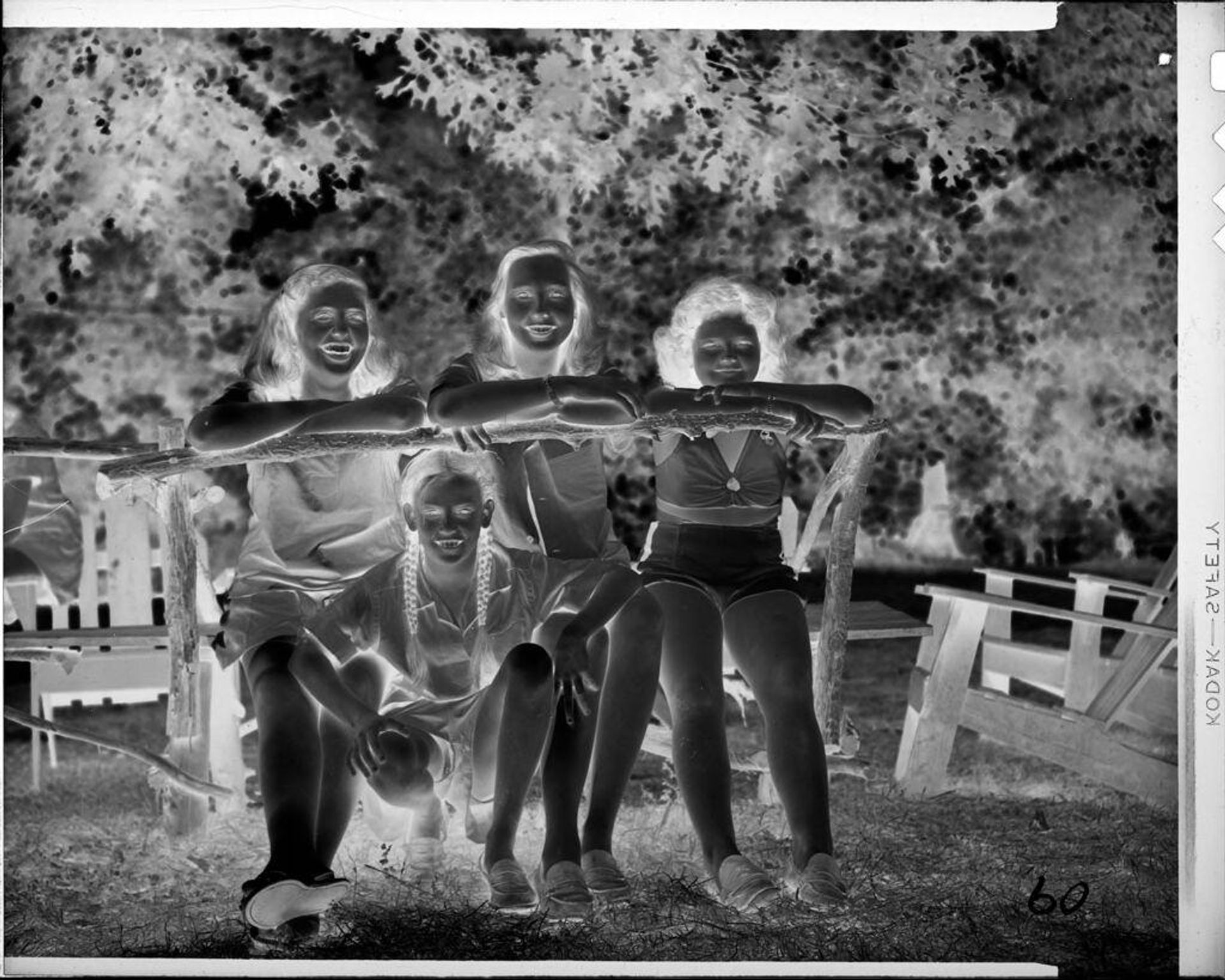 Untitled (four girls on bench outside) by C. Bennette Moore