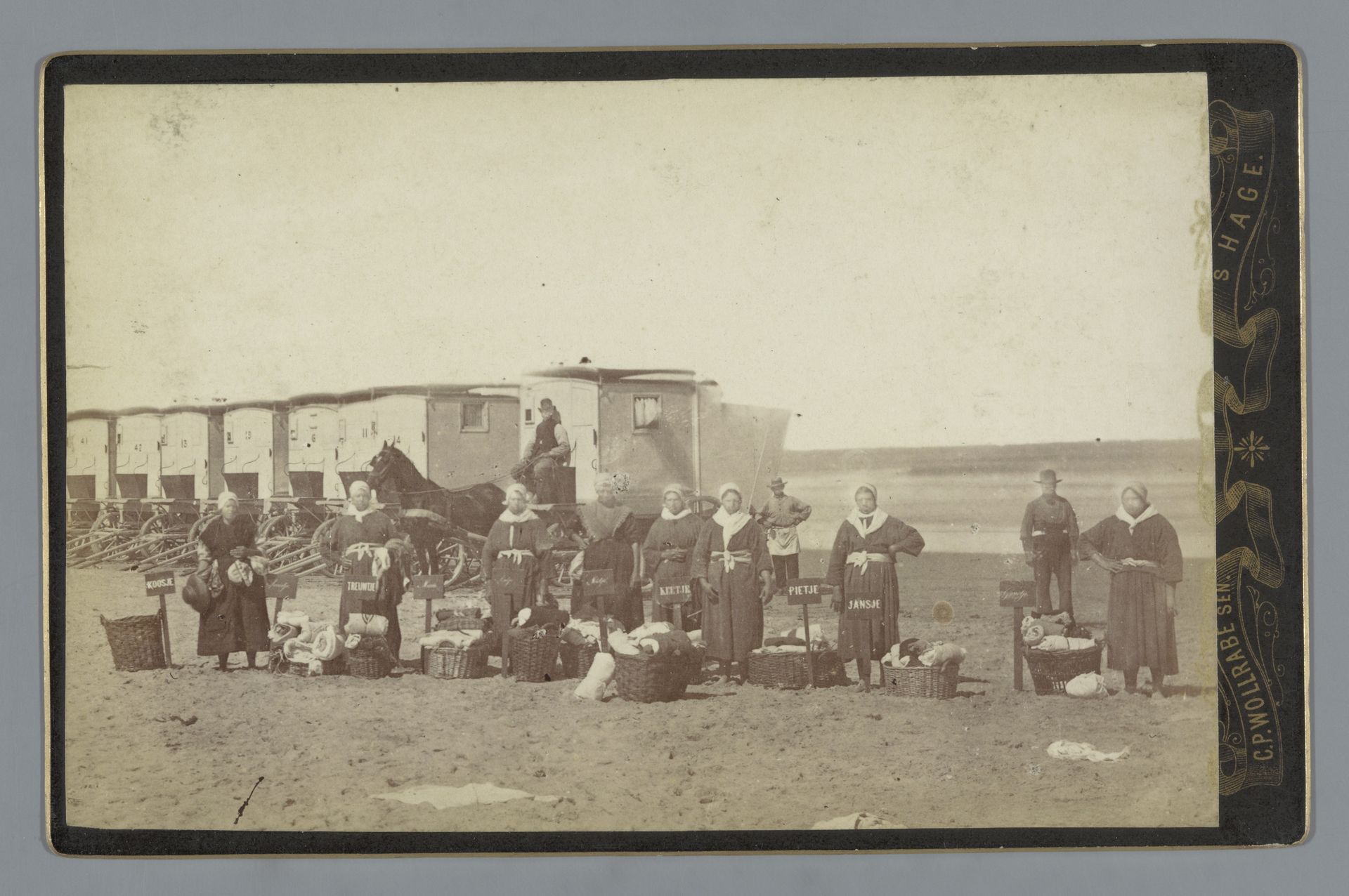 Verhuursters van handdoeken op het strand van Scheveningen, met op de achtergrond een rij badkoetsen by Carl Philip Wollrabe