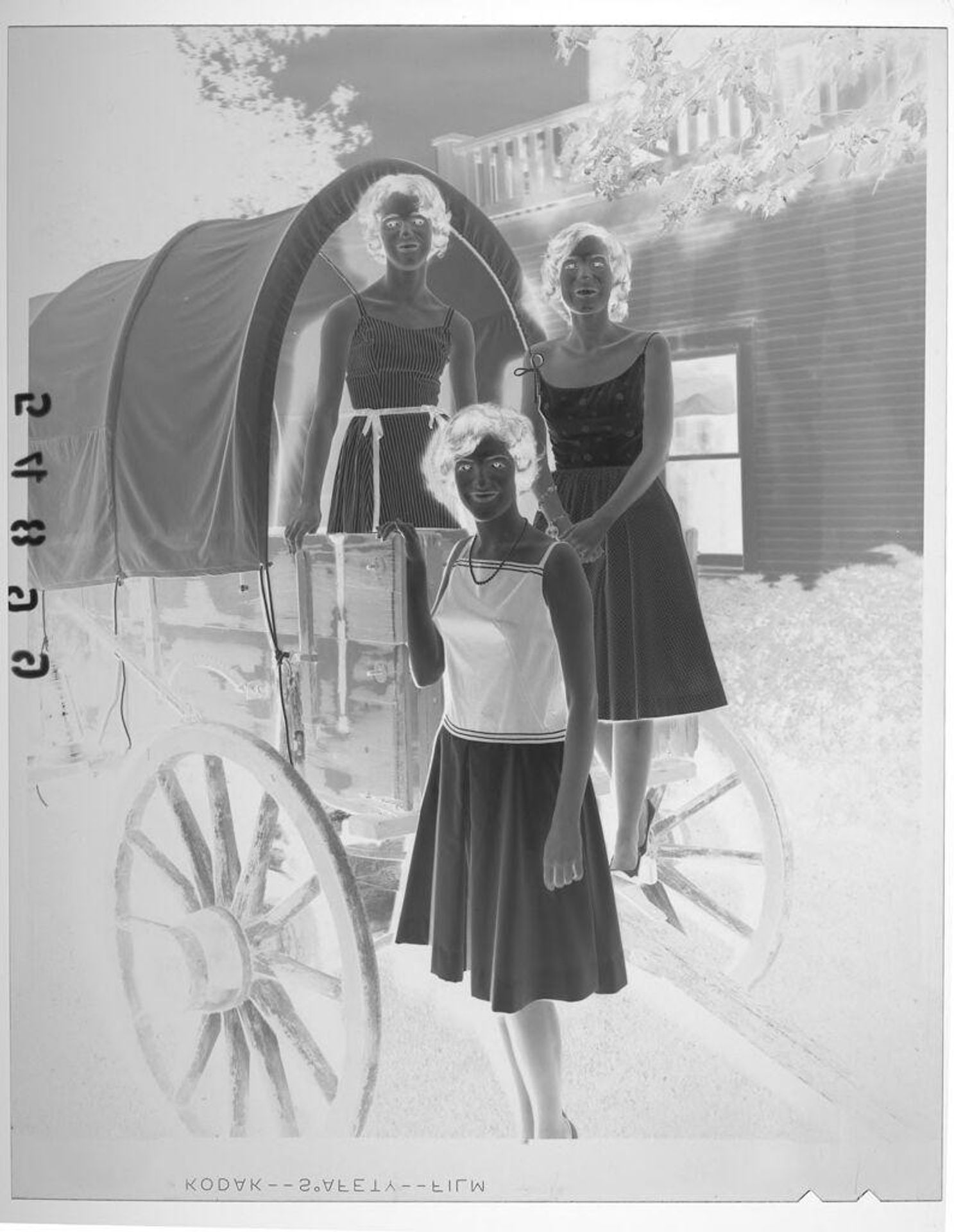 Untitled (three young women posing by covered wagon at graduation party) by Martin Schweig