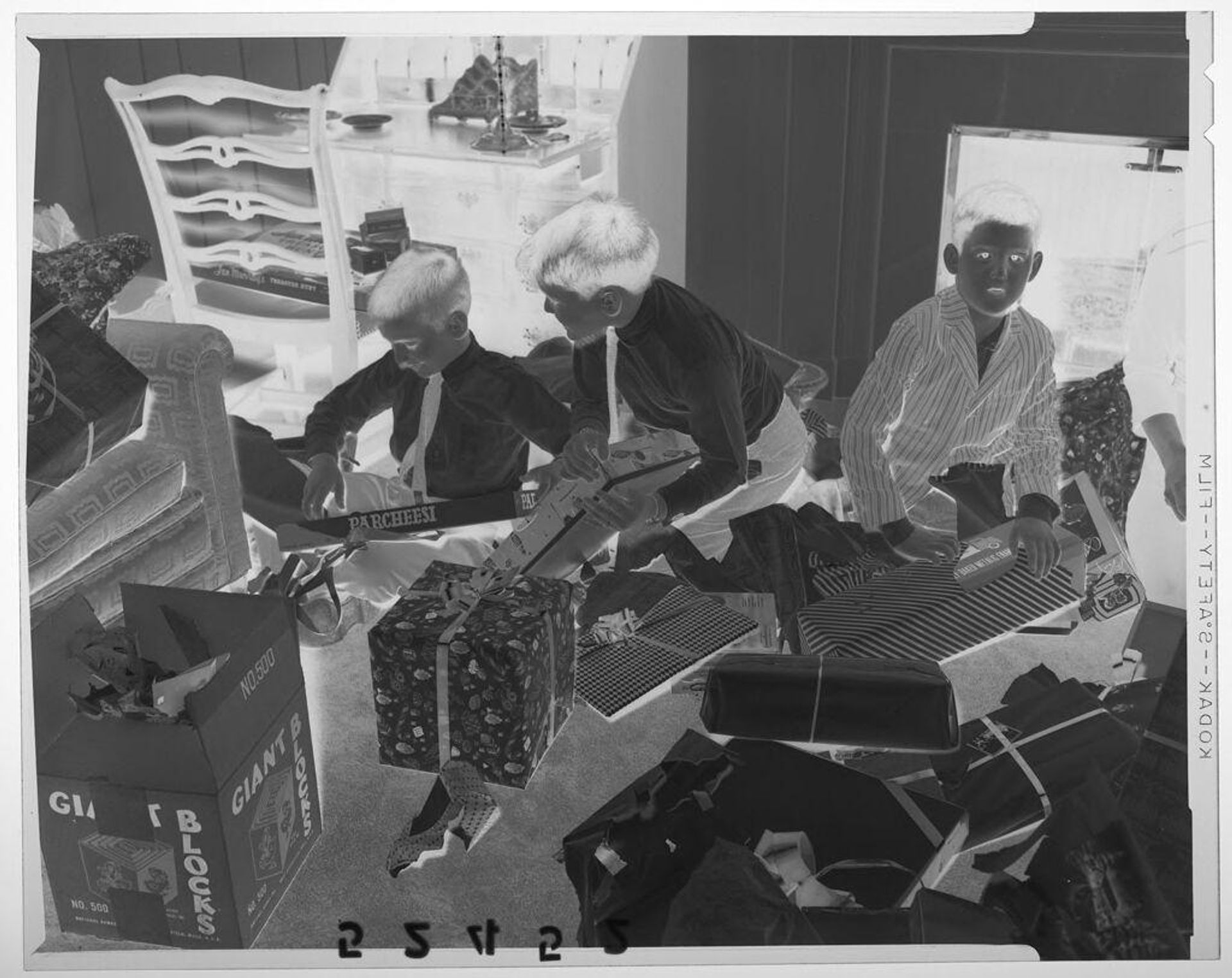 Untitled (three boys opening Christmas gifts on living room floor) by Martin Schweig