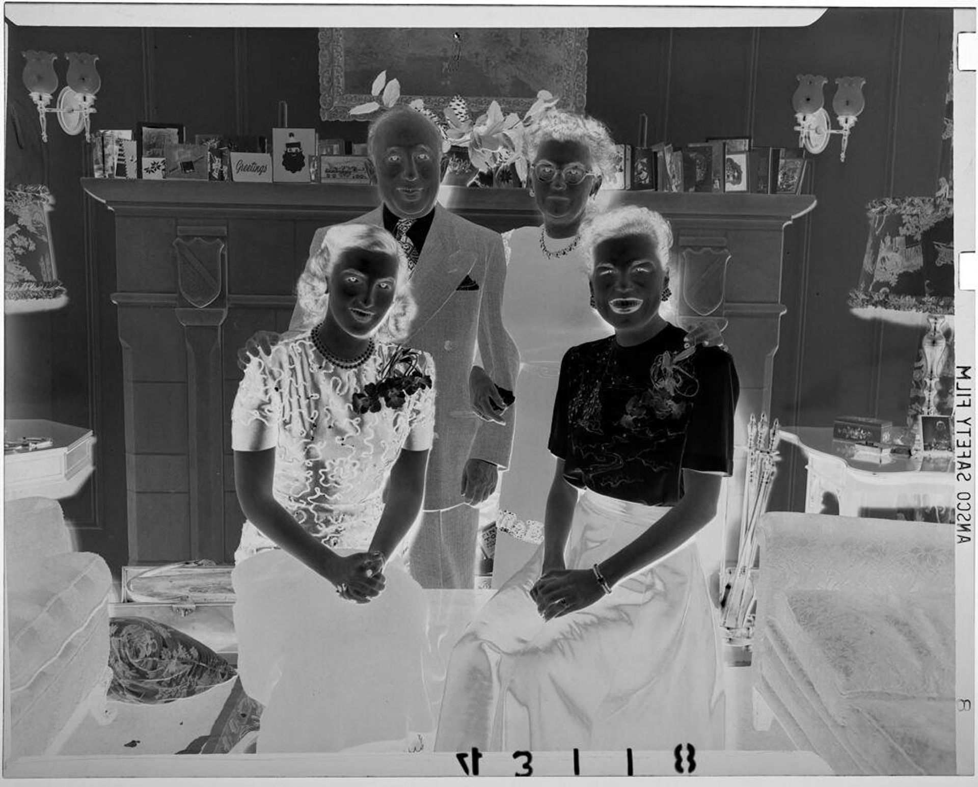 Untitled (middle-aged couple and two younger woman posed in living room at Christmas time) by Martin Schweig