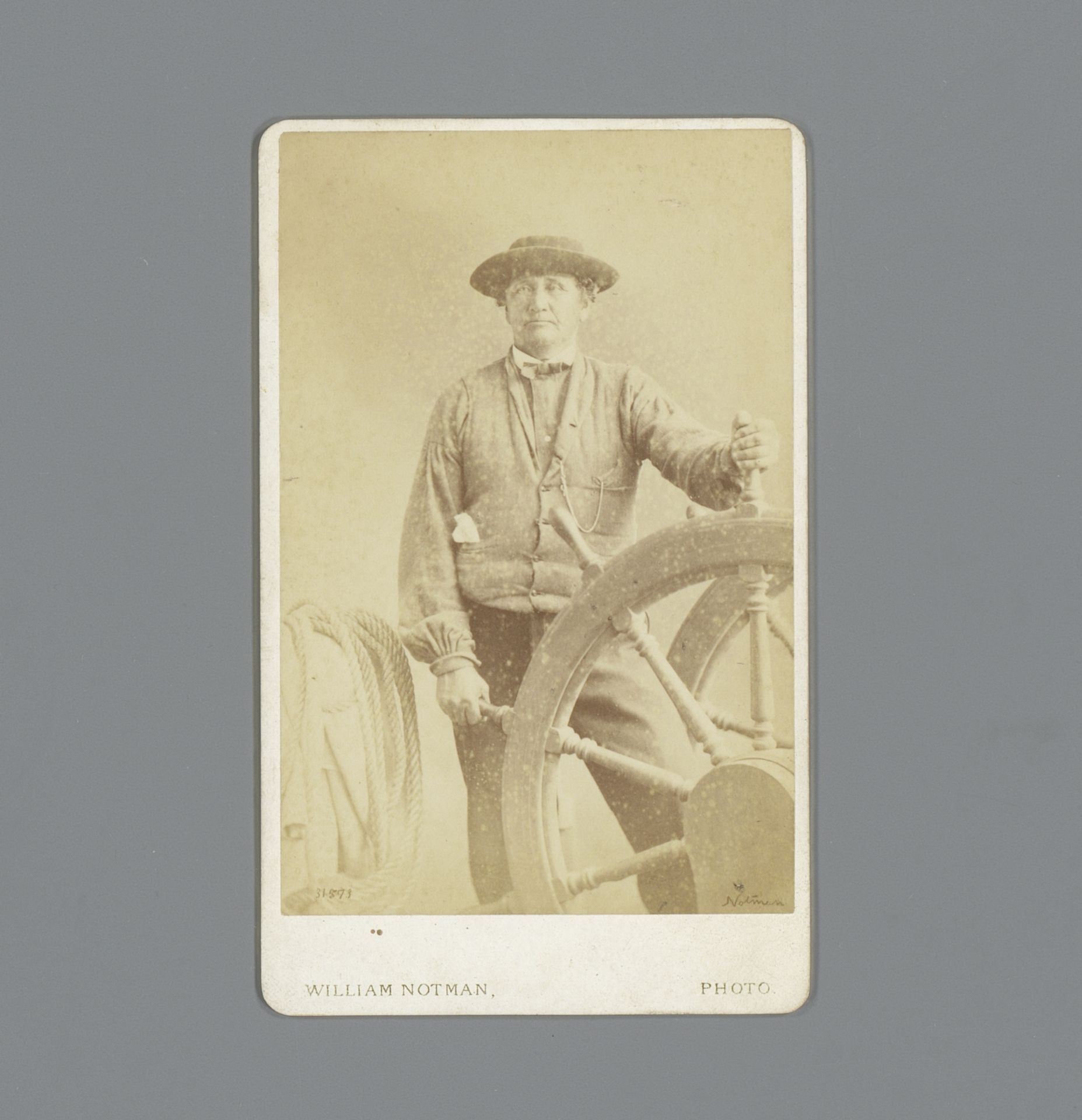Portret van een onbekende man achter scheepswiel by William Notman