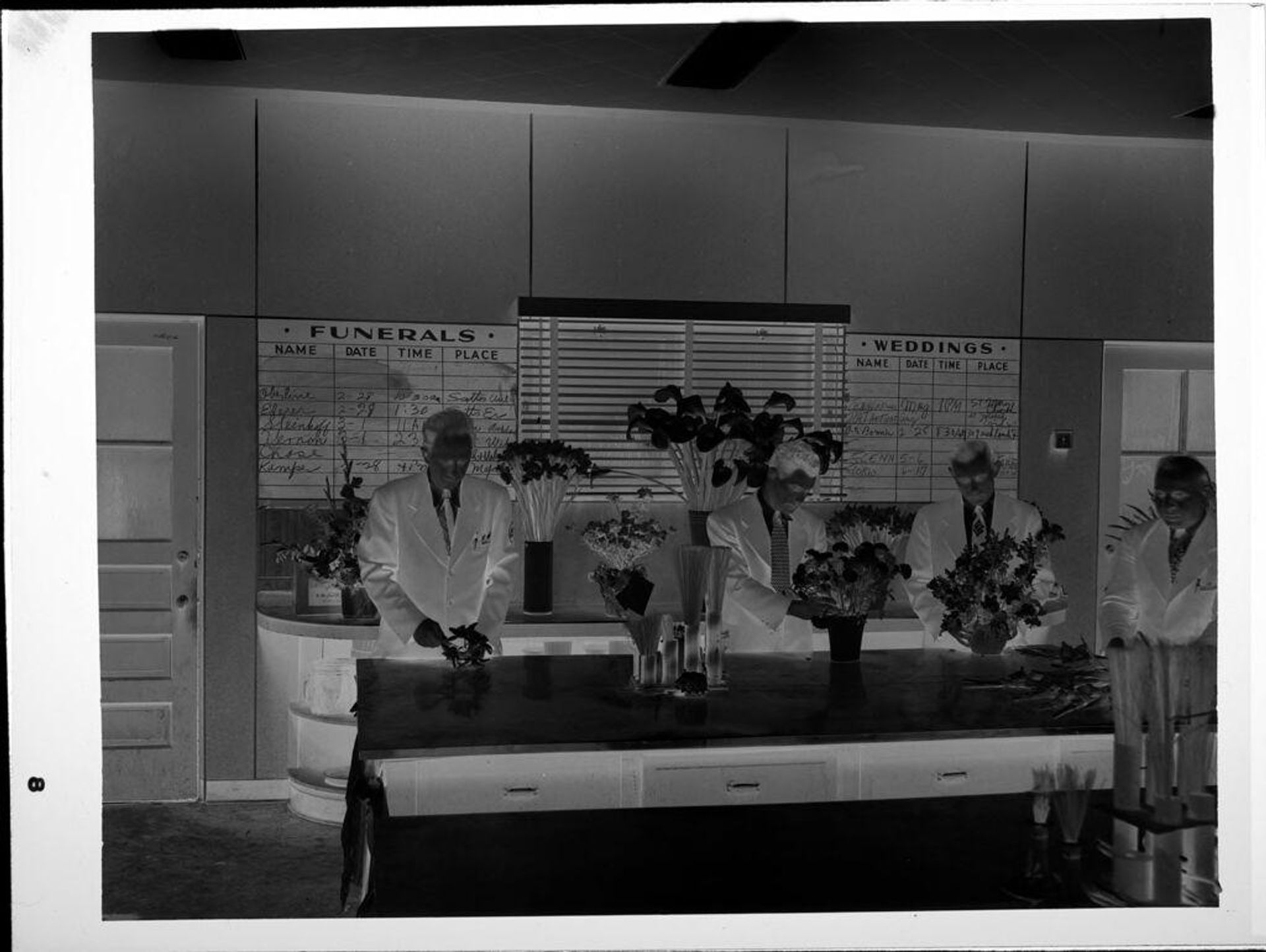Untitled (men working in flower shop) by John Howell