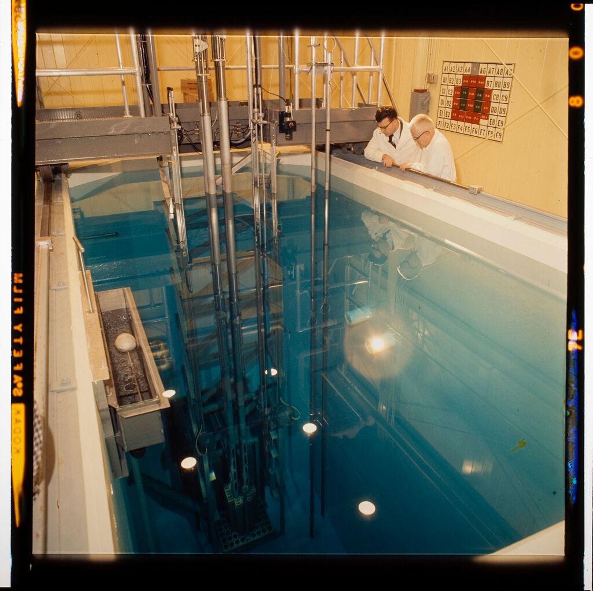 Untitled (scientists looking into pool of water at research facility) by Jack Gould
