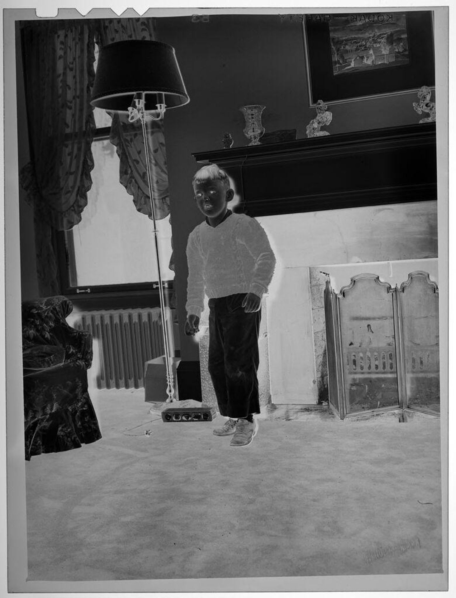 Untitled (boy standing in living room) by Lucian and Mary Brown
