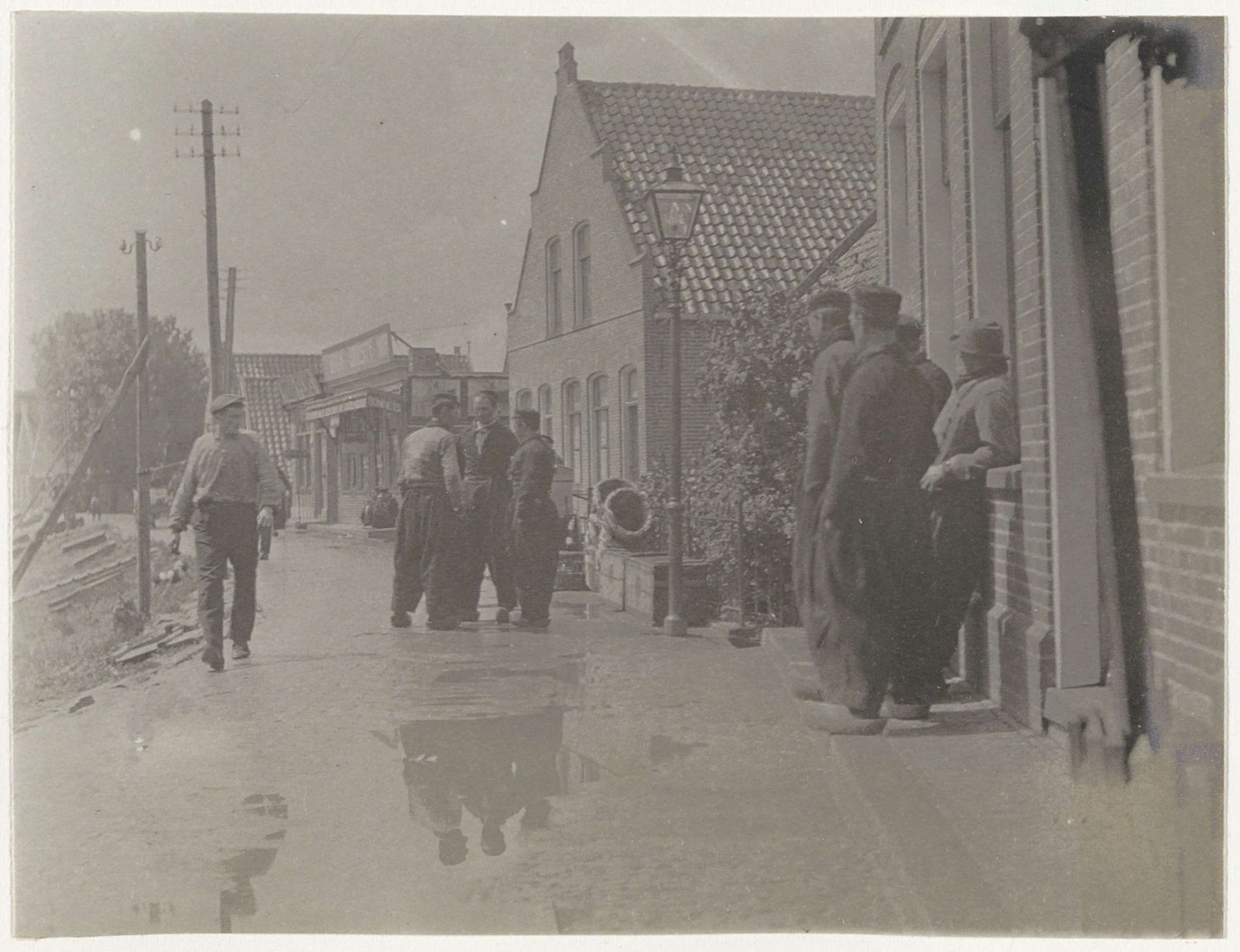 Mannen in Volendamse kleding op een dijk by G. Hidderley