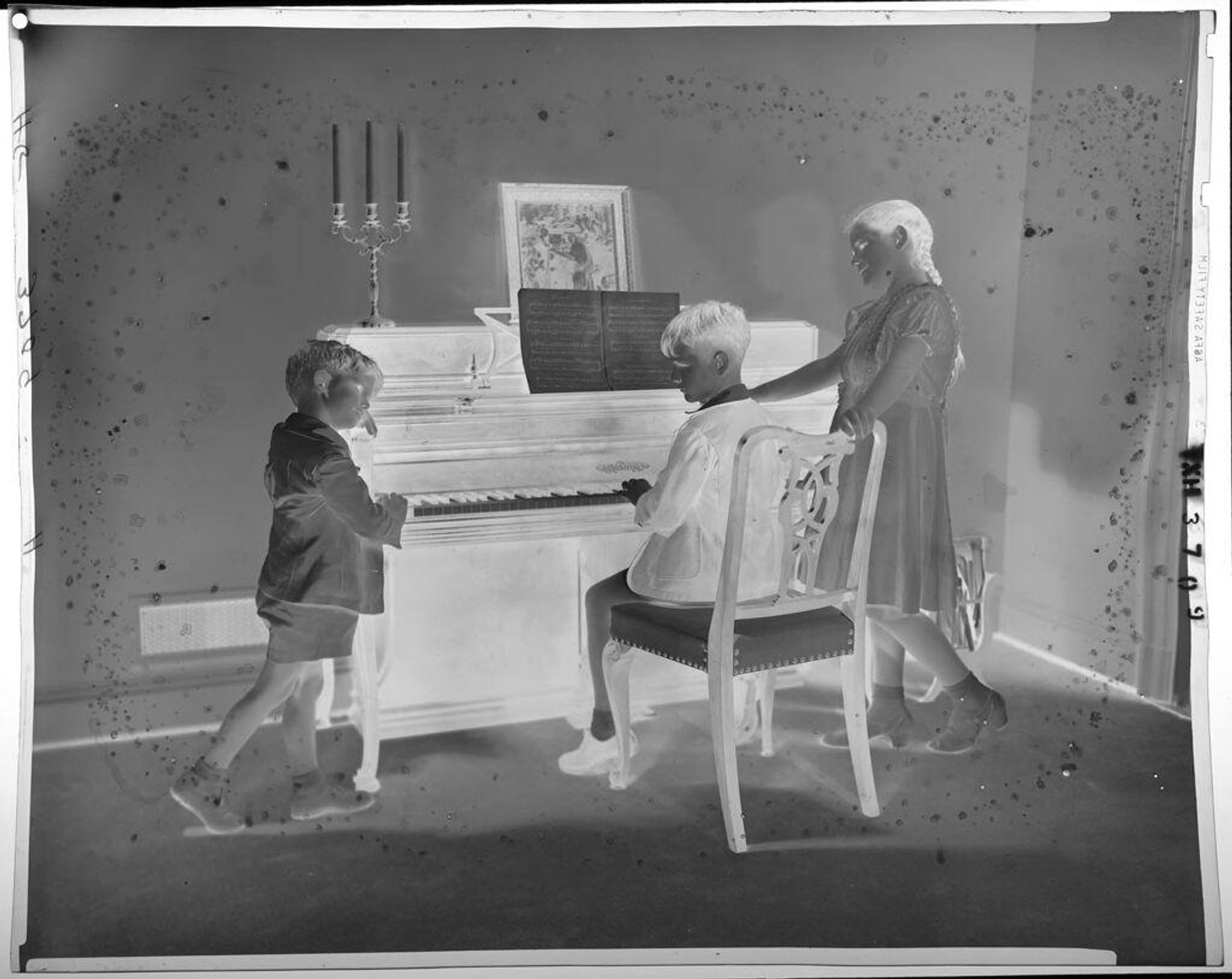 Untitled (boy seated at piano, flanked by siblings) by Paul Gittings