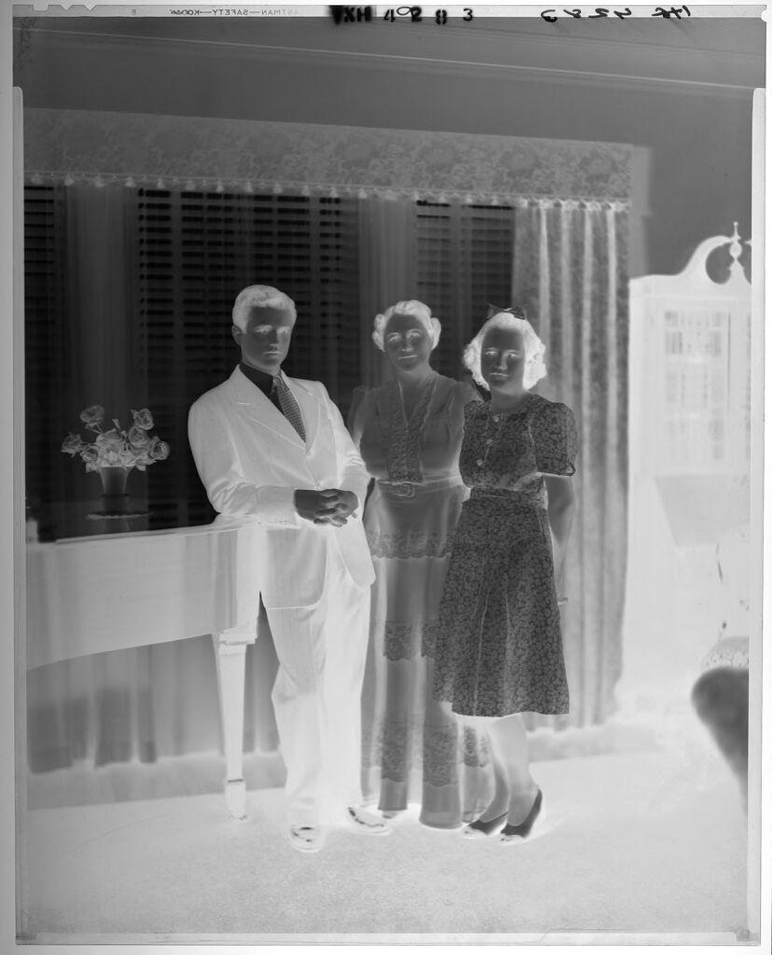 Untitled (mother with son and daughter standing by piano) by Paul Gittings