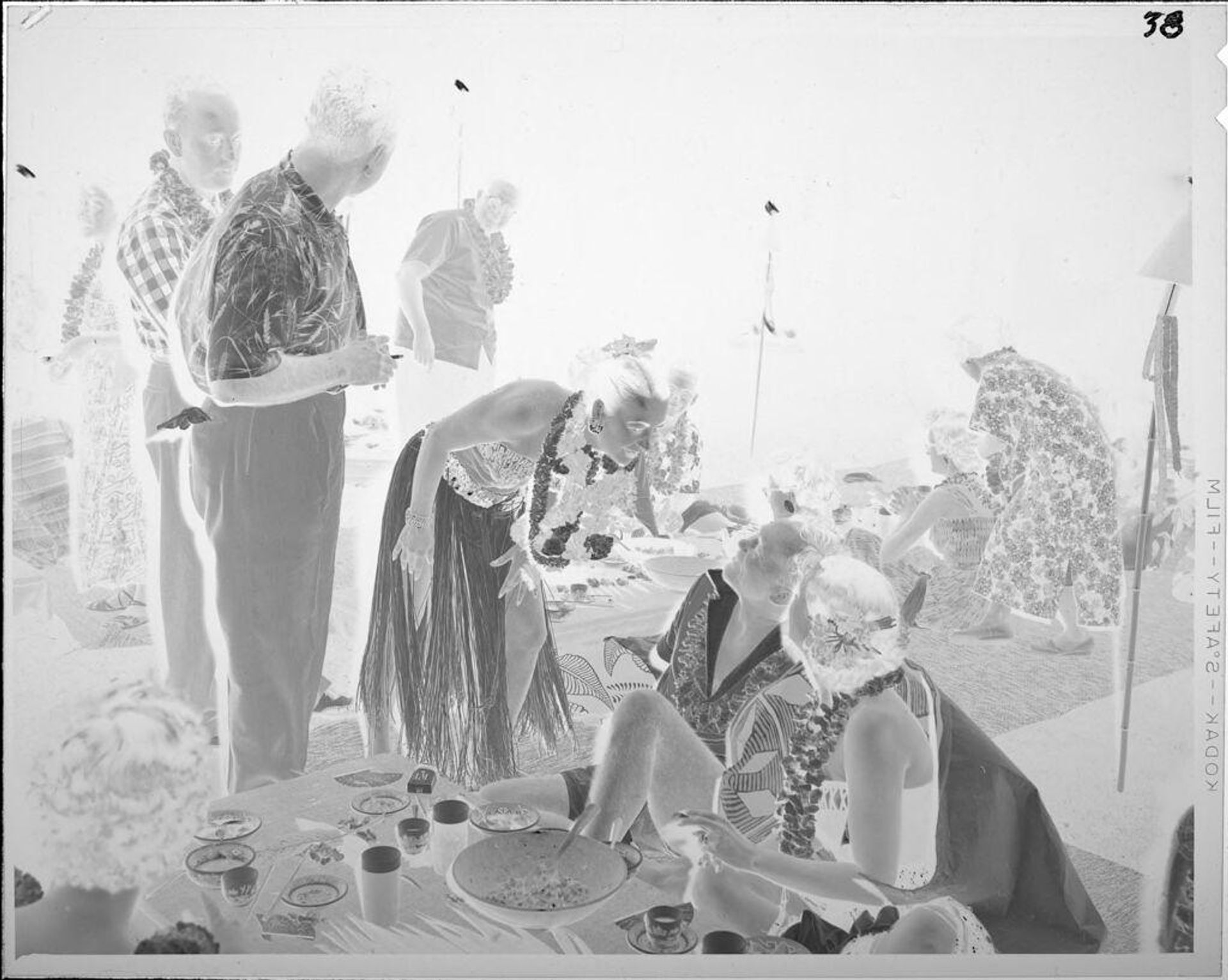 Untitled (people eating at luau) by Lucian and Mary Brown