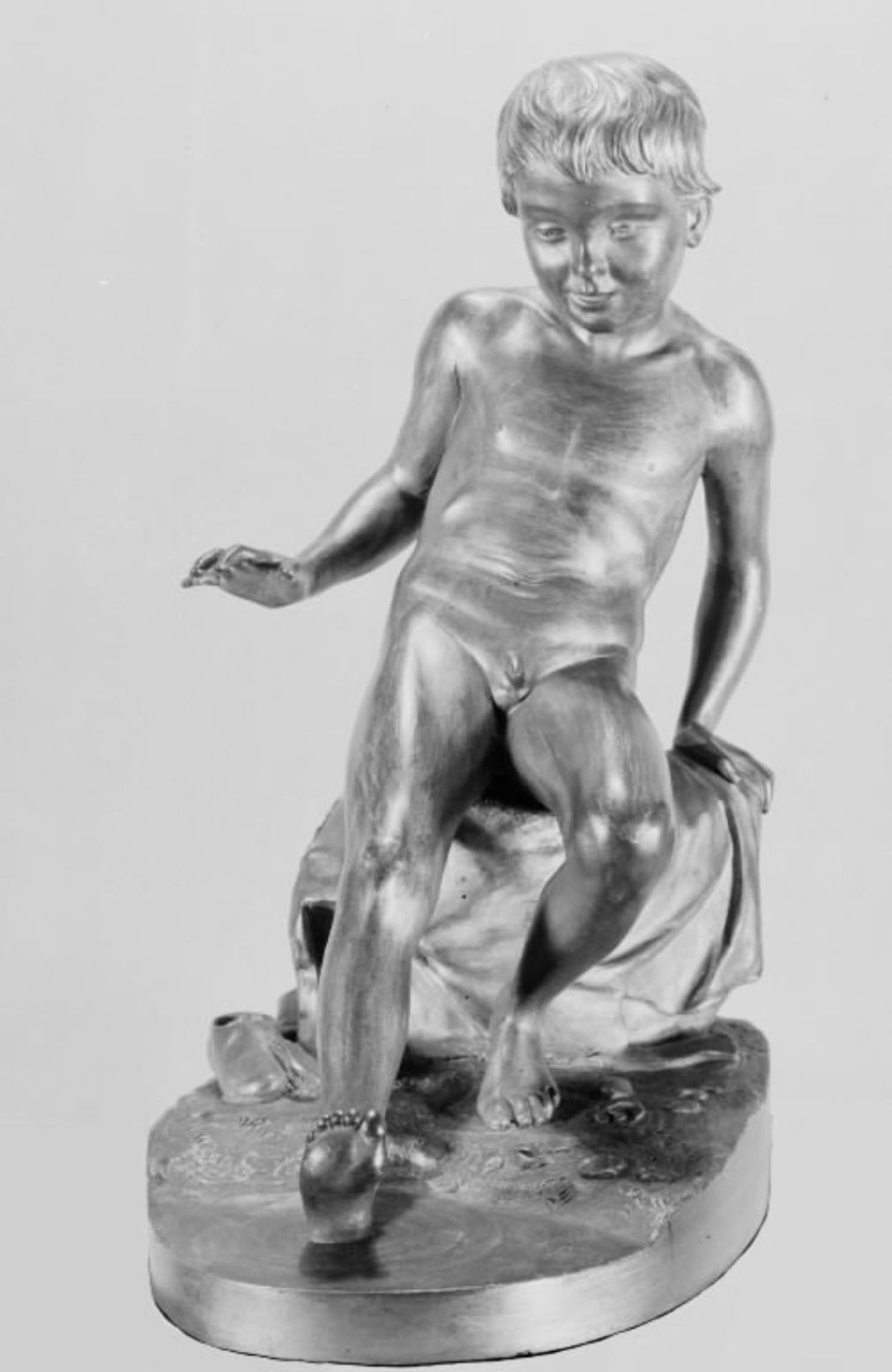 En dreng der vil bade. Siddende nøgen dreng, der prøver vandet med sin ene fod by O. Evens