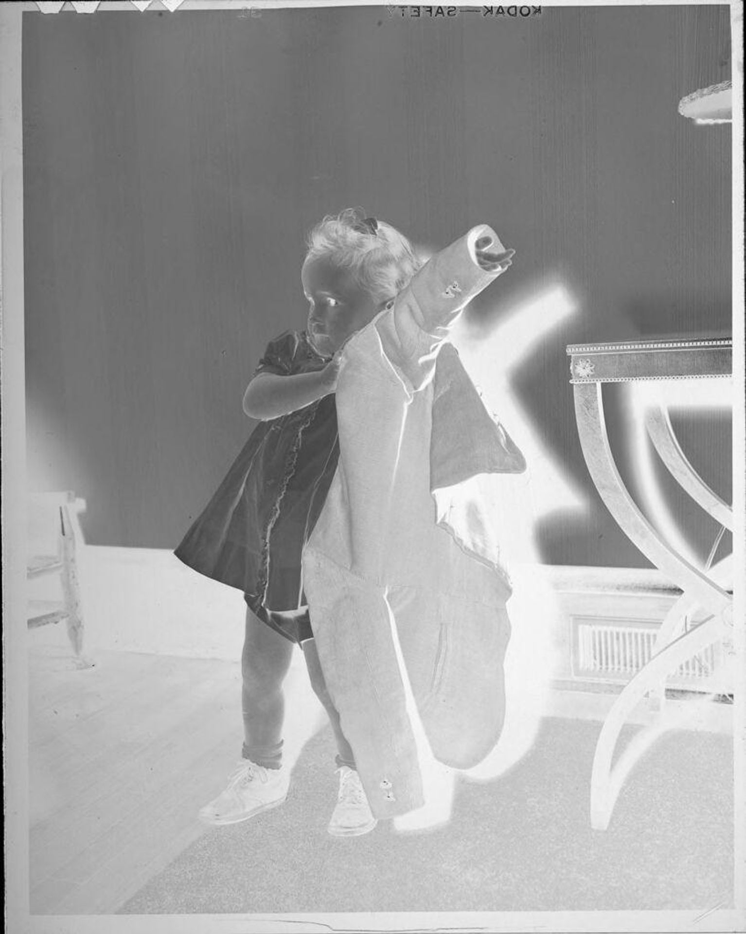 Untitled (little girl putting on coat) by Lucian and Mary Brown