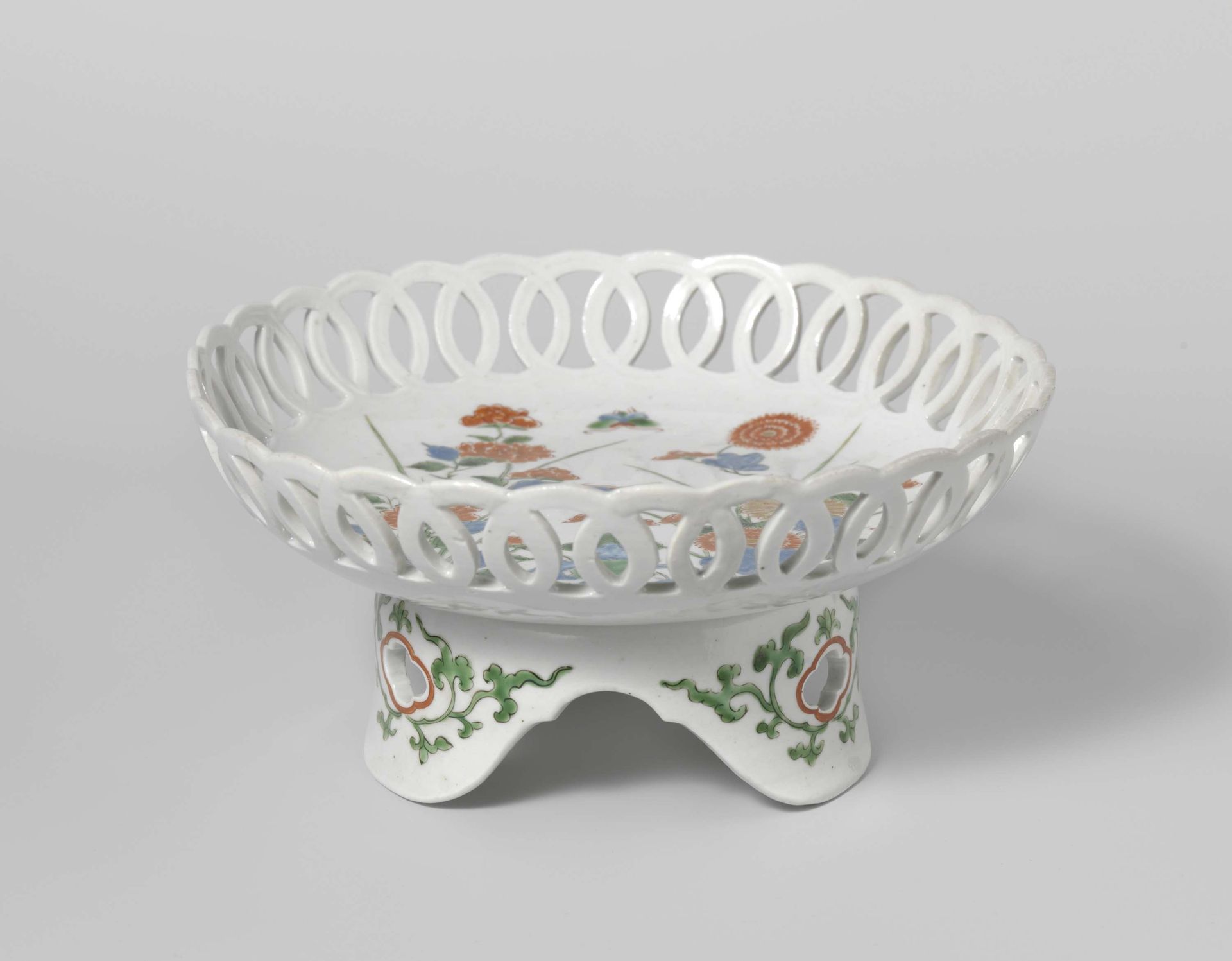 Saucer-dish on tripod with flowering plants near rocks by Anonymous