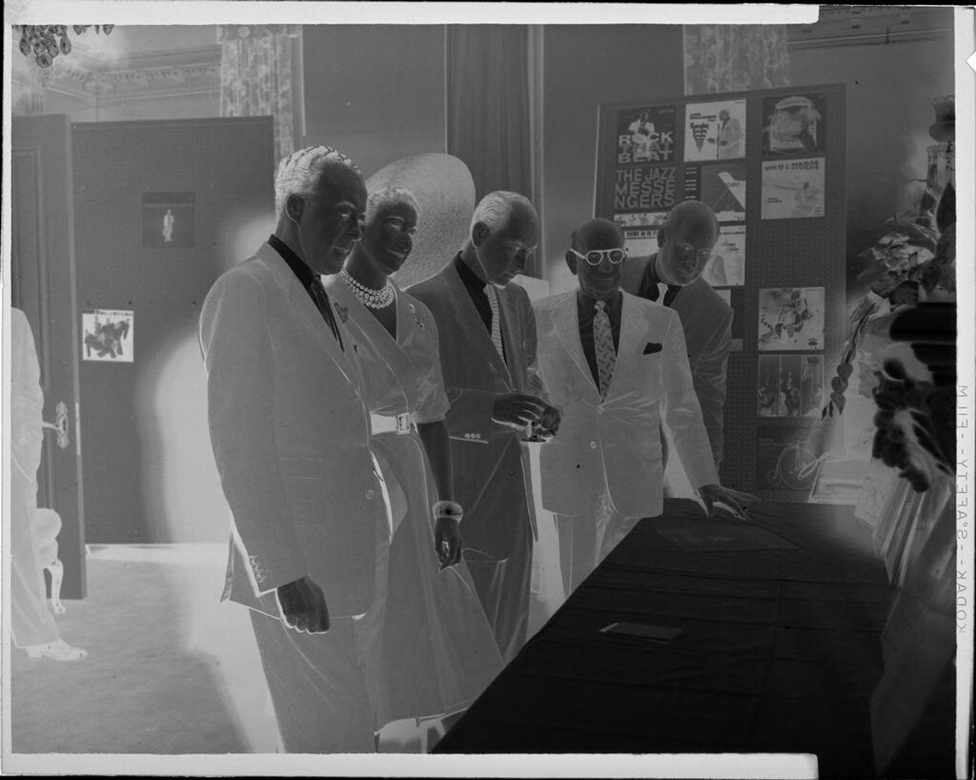 Untitled (men and woman next to long table) by Peter James Studio