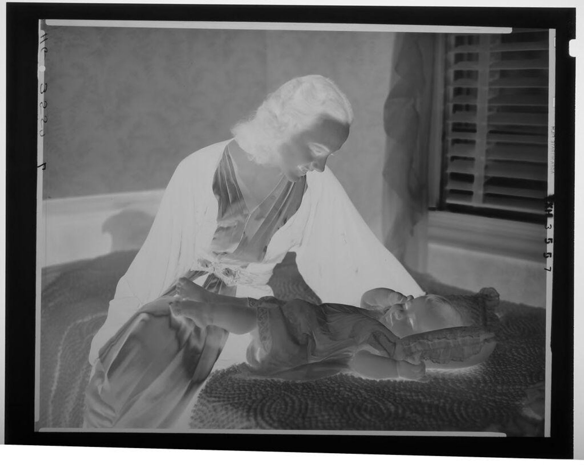 Untitled (woman leaning over baby on bed, Houston, Texas) by Paul Gittings