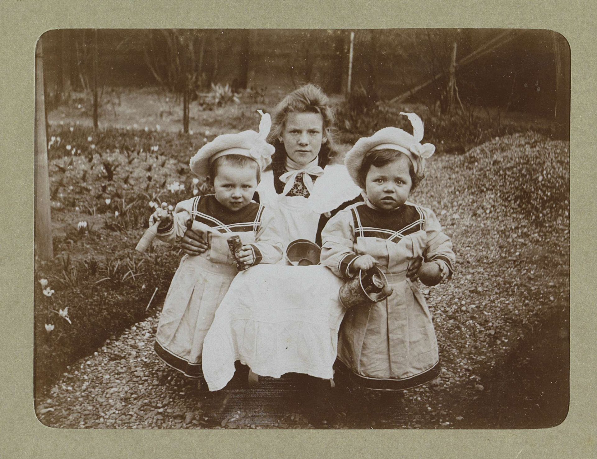 Jonge vrouw en twee peuters met dezelfde jassen en baretten, waarschijnlijk de tweeling Ad en Johanna van der Kop met een familielid by Willem Carel van der Kop