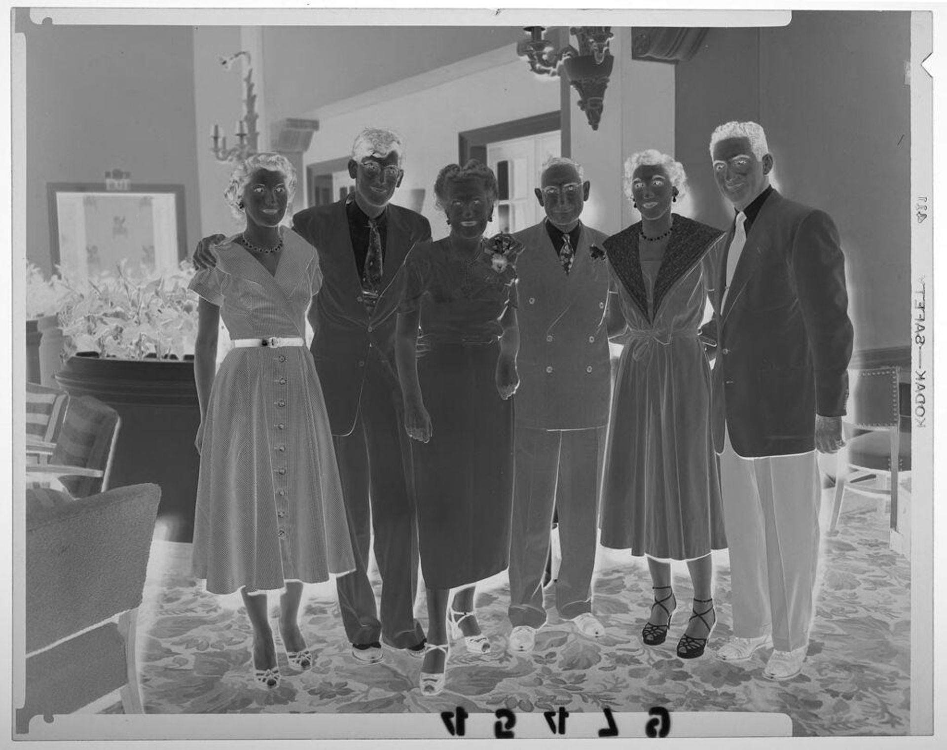 Untitled (two young couples with one older couple posed by partition with plants at party by Martin Schweig