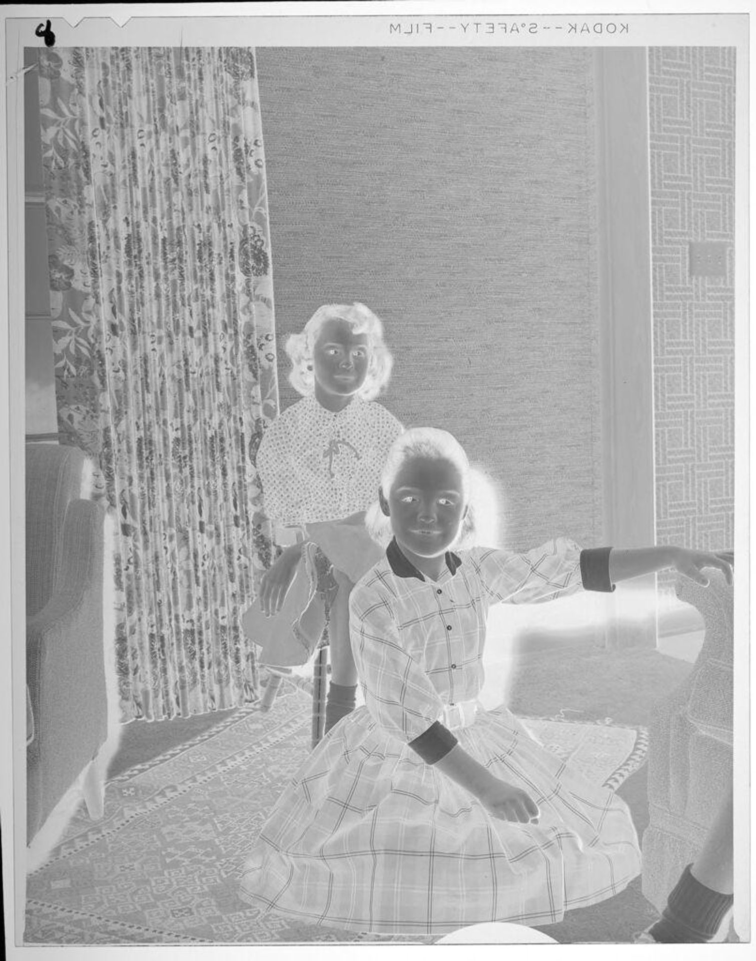 Untitled (portrait of two girls seated in living room) by Lucian and Mary Brown
