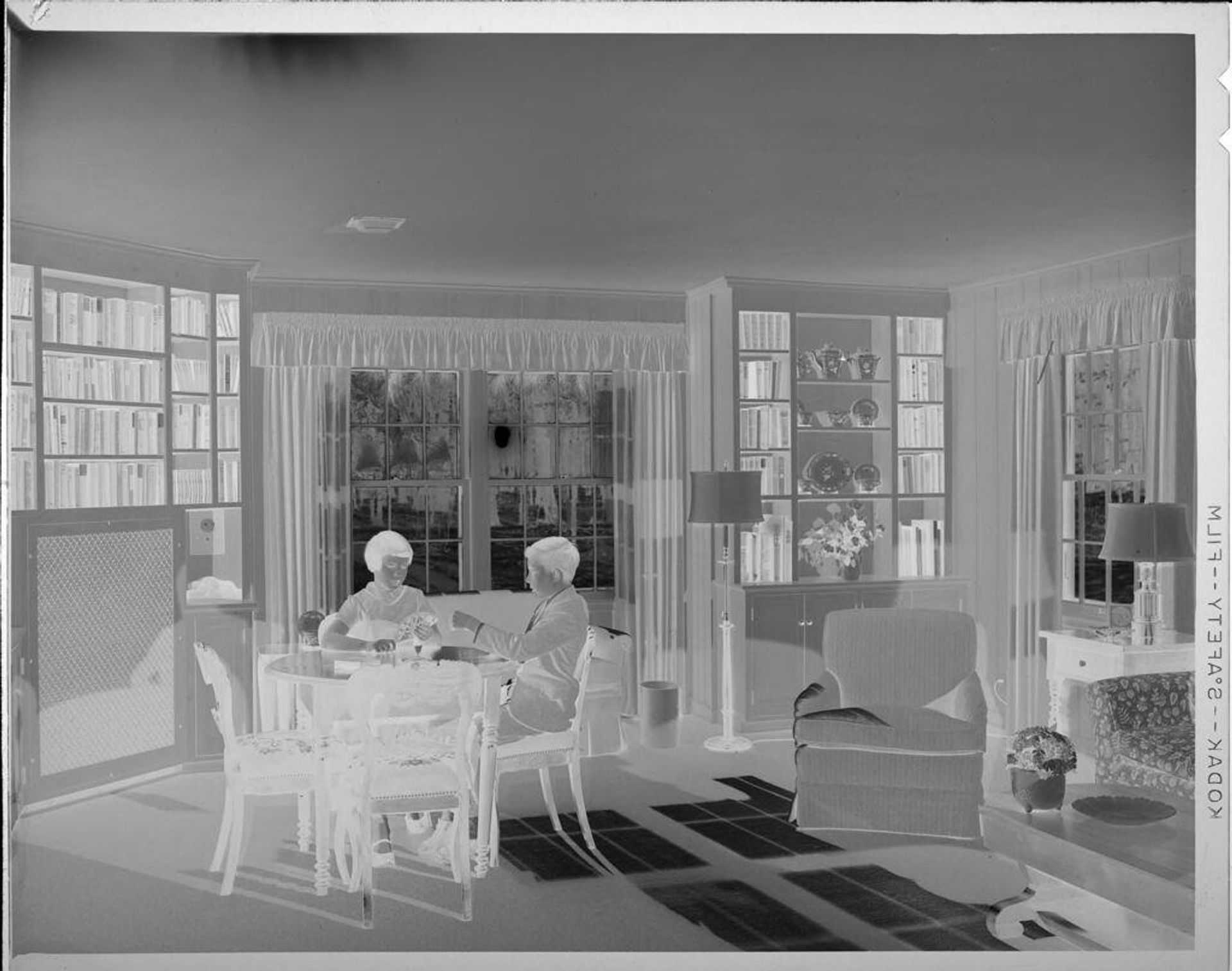 Untitled (boy and girl playing cards in living room) by Lucian and Mary Brown