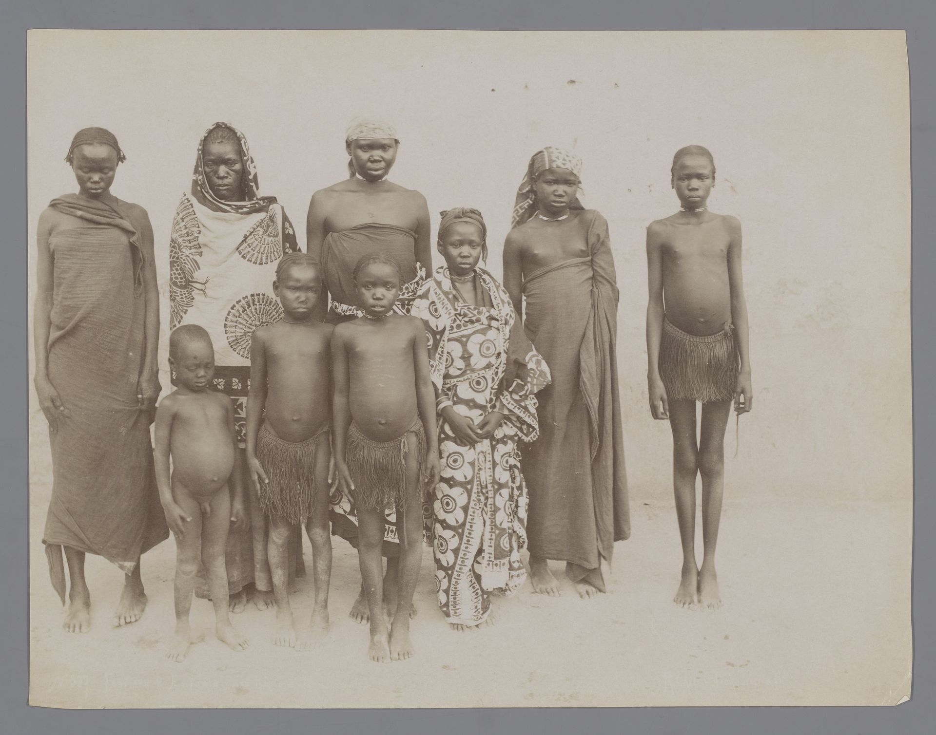 Groepsportret van negen onbekende vrouwen en kinderen uit Frans-Equatoriaal-Afrika by G. Lekegian & Co.