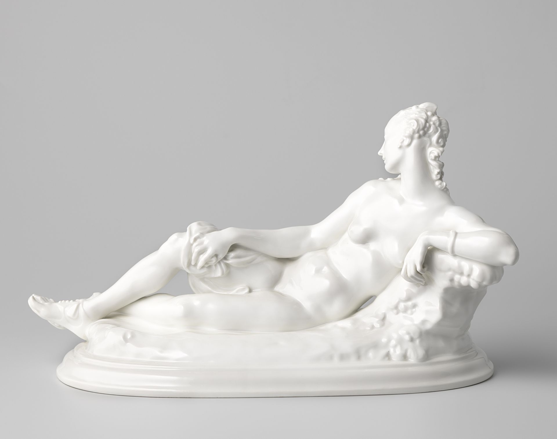 Figure in the shape of a reclining woman on a rock by Königliche Porzellan Manufaktur