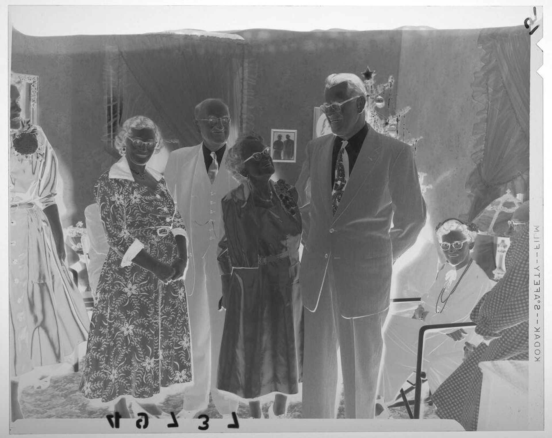 Untitled (two couples posing in living room at Christmas party) by Martin Schweig