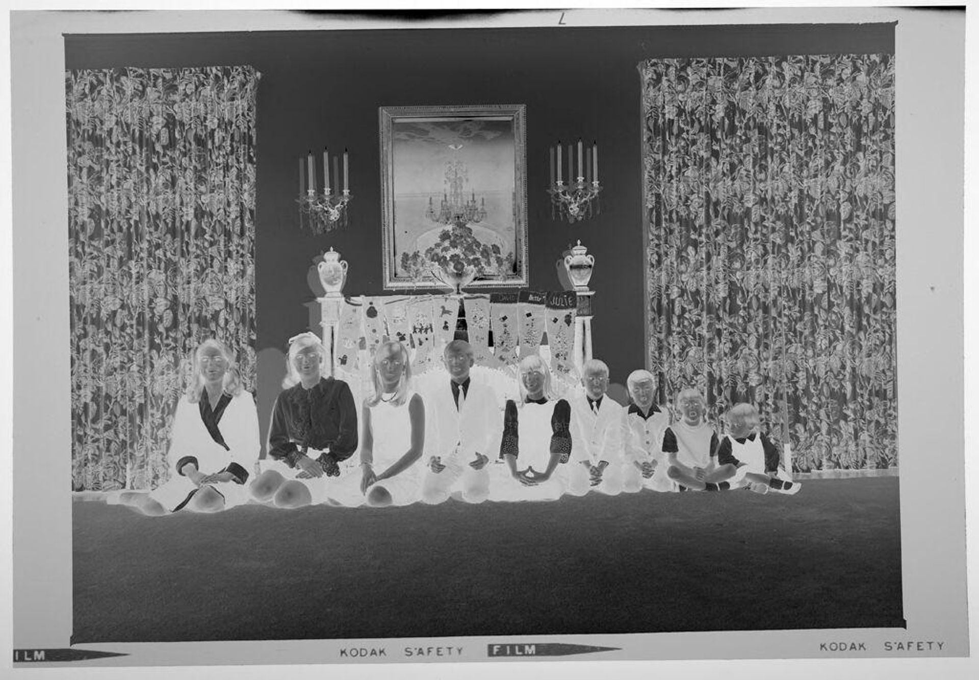Untitled (nine children posed sitting in front of fireplace decorated with stockings) by Martin Schweig