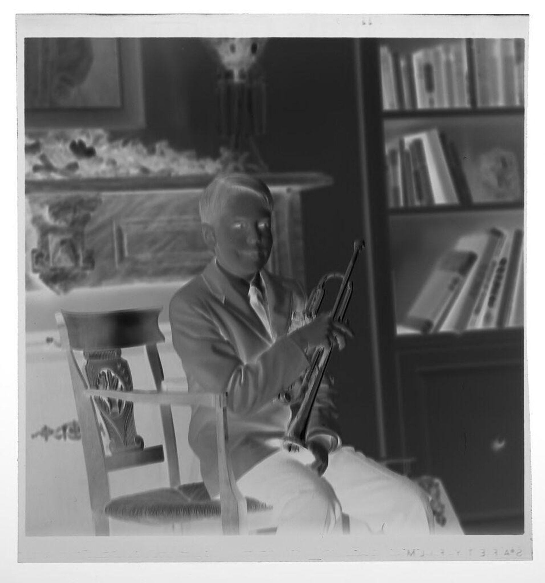 Untitled (boy sitting with trumpet in front of fireplace) by Martin Schweig