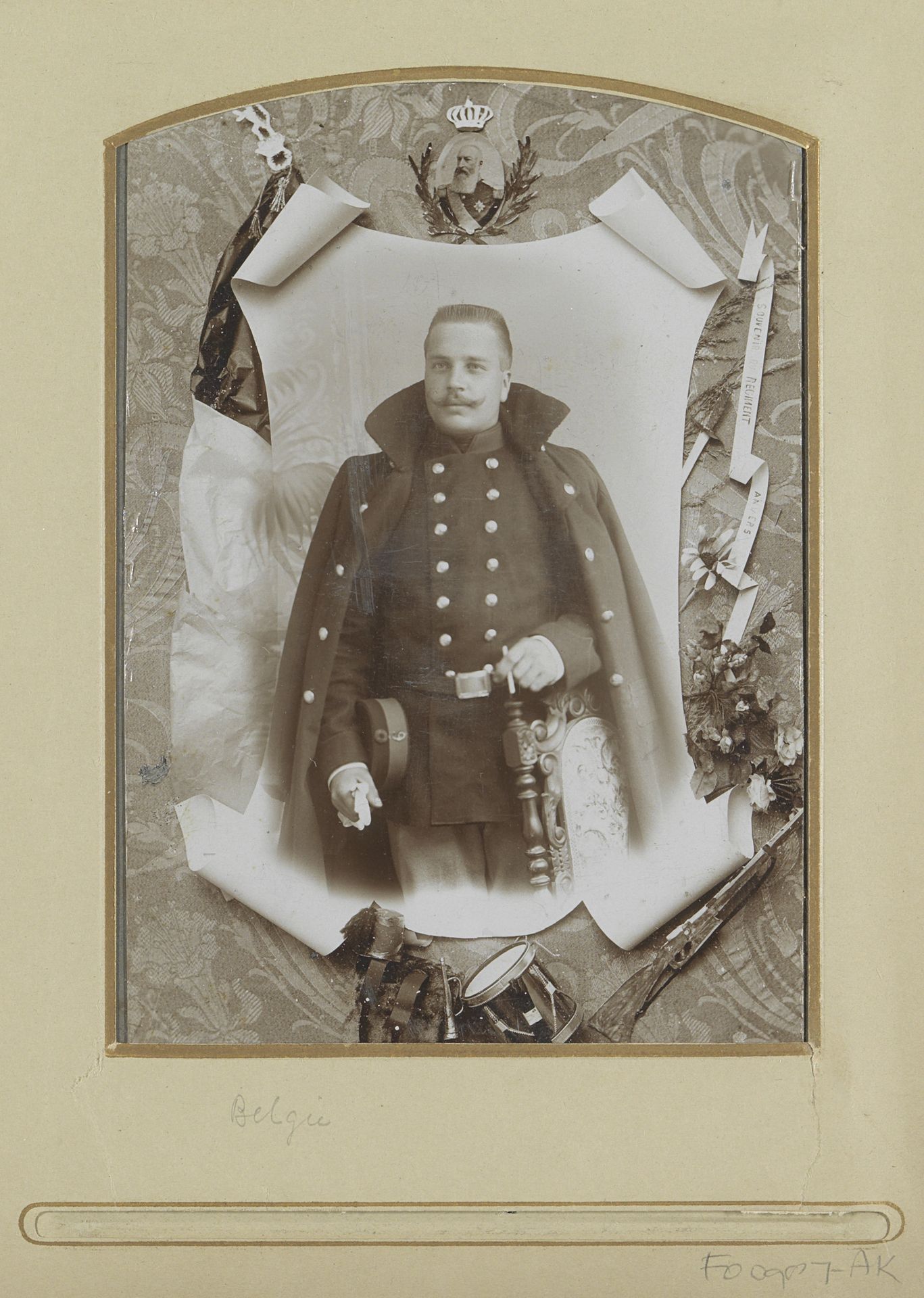 Portret van een Belgische militair, omlijst met geweer, trommel, miniatuurportret van koning Leopold II van België en een wimpel met de tekst 'souvenir du regiment Anvers' by Georges Halleux-Mertens
