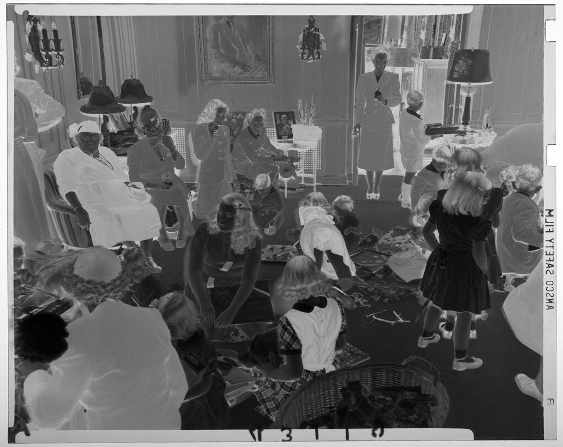 Untitled (children opening presents while adults sit in chairs inside house) by Martin Schweig