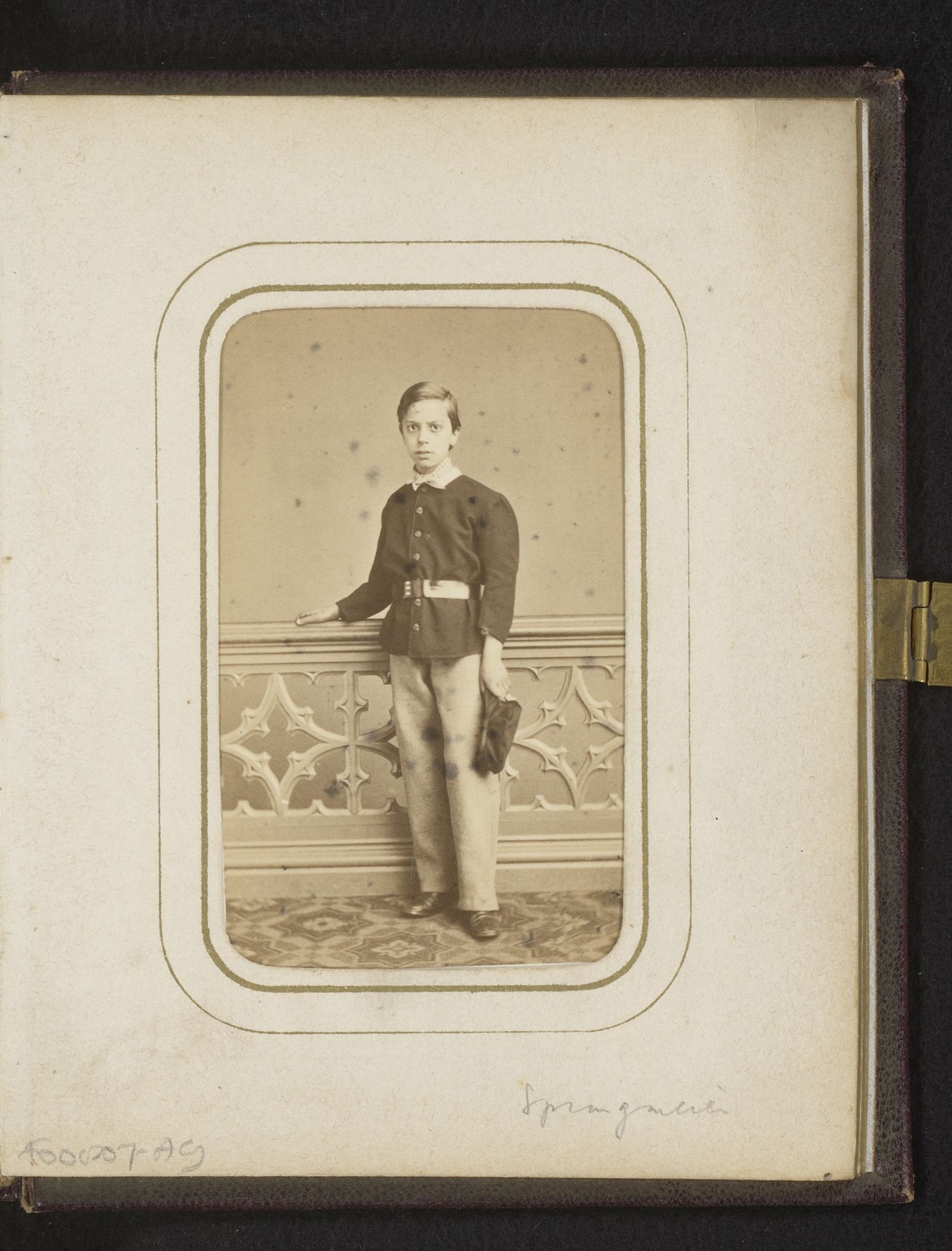 Portret van een jongen met pet in de hand, staand bij een balustrade by F. Springmeier